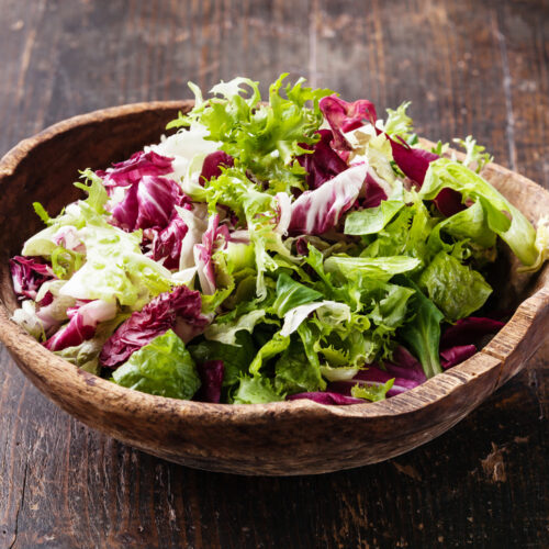 Fresh salad leaves mix in wooden bowl